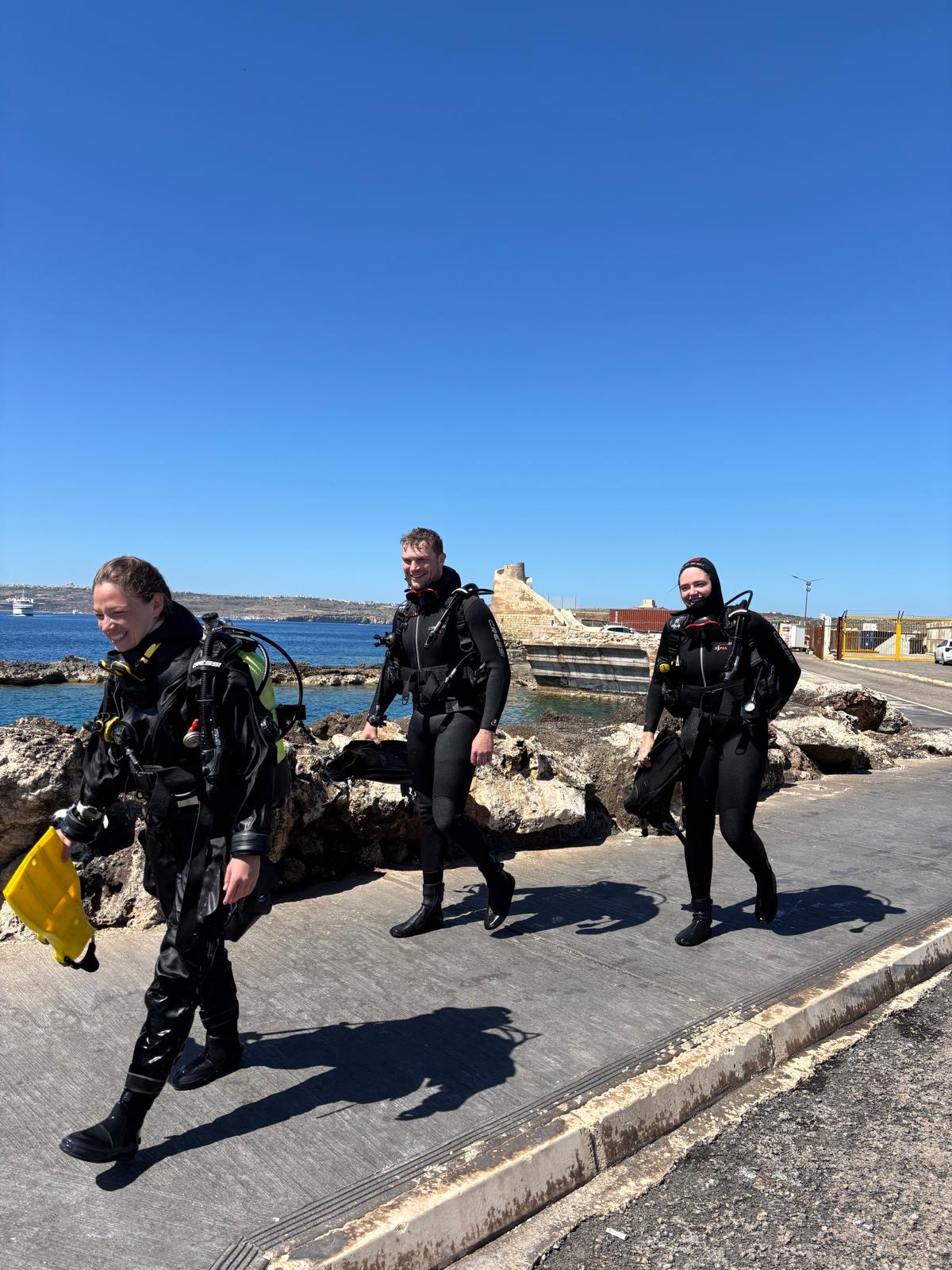 Happy divers walking back after the dive